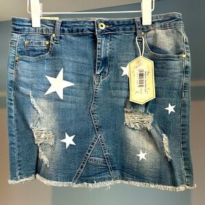 NWT Mignon Jean skirt. Size large. Denim with star pattern. Distressed detail.